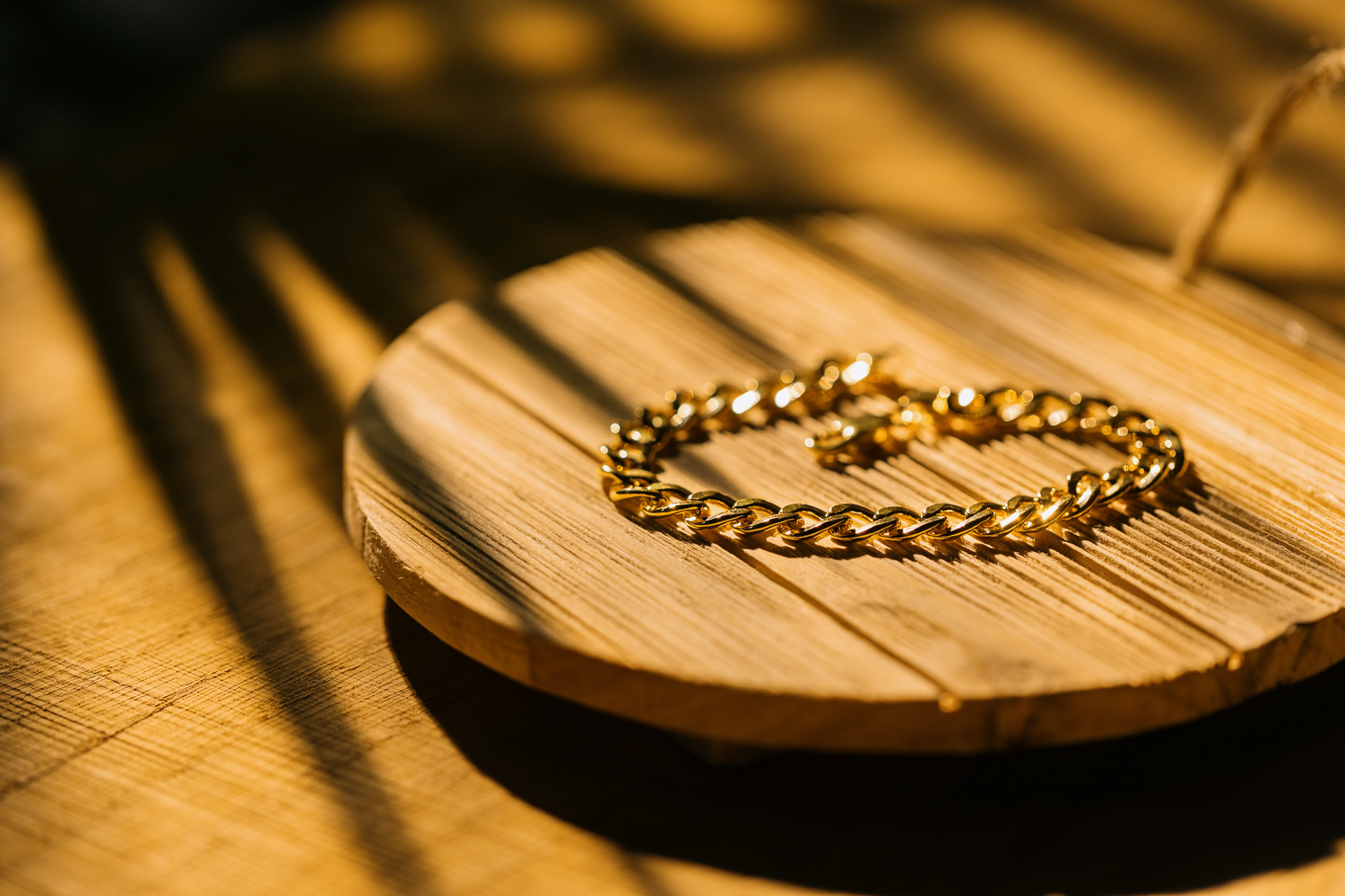 a gold bracelet on a wooden pedestal